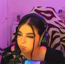 a woman wearing headphones and a microphone is sitting in front of a microphone .