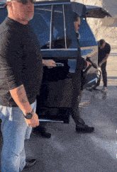 a man with a tattoo on his arm is standing next to a man with a gun