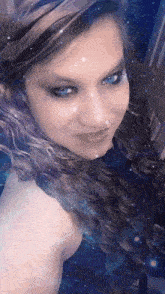 a woman with blue eyes is taking a selfie with a galaxy background