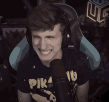 a man wearing a pikachu t-shirt is talking into a microphone