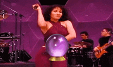 a woman is standing on a stage with a purple ball in her hand .