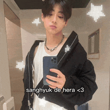 a young man taking a selfie with the caption sanghyuk de hera < 3 on the bottom
