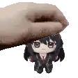 a hand is holding a stuffed doll on top of another doll .