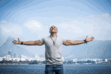 a man with his arms outstretched in front of a city