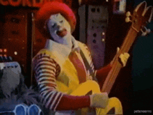 mcdonald 's clown is playing a guitar in a mcdonald 's advertisement .