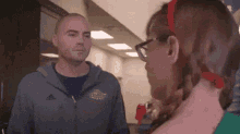 a man and woman are standing next to each other in a hallway .