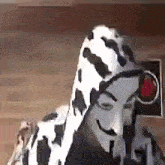 a person wearing a dalmatian costume with a red light behind them .