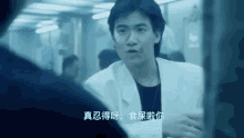 a man in a white lab coat is talking to another man in a dark room .