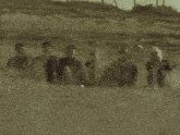 a group of people are sitting in the sand on a beach