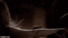 a close up of a person 's face with smoke coming out of it in a dark room .