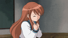a girl with long brown hair has her eyes closed and her hands together