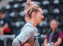 a woman holding a basketball and wearing a shirt that says ff