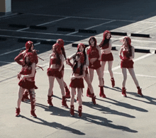 a group of women in red outfits are standing on a parking lot