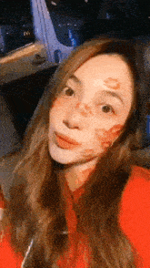 a woman is taking a selfie with lipstick kisses on her face .