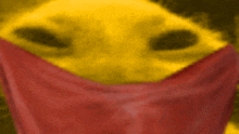 a close up of a yellow object with a red cloth covering it 's face