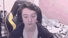 a young man wearing headphones is sitting in a gaming chair in a room .