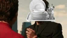 a man in a suit has a tray of plates and silverware on his head