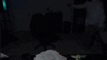 a person standing in a dark room with a stuffed animal on a table