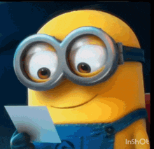 a close up of a minion wearing goggles looking at a piece of paper