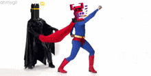 a man in a superhero costume is standing next to a man in a black cape .