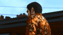 a man in a floral shirt is standing in front of a roof