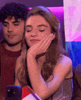 a woman is covering her face with her hand while a man looks on