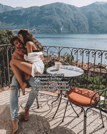 a man is carrying a woman in his arms on a balcony