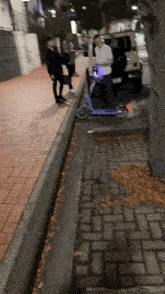 a person riding a purple scooter on a sidewalk