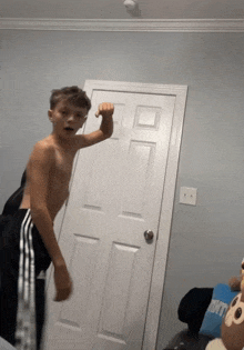 a shirtless boy is standing in front of a door that says nike