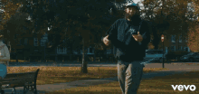 a woman sits on a bench next to a man in a video that says vevo on the bottom