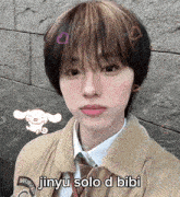 a young man wearing a tan jacket and tie with the words jinyu solo d bibi written on his face