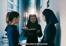 two nuns are standing in a hallway and one is reading a book and the other is saying i found this story in the journal