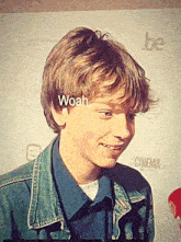 a young boy in a denim jacket is smiling with the word woah above his head