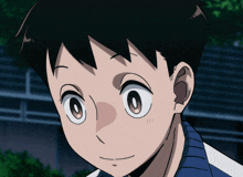 a close up of a boy 's face with a blue shirt