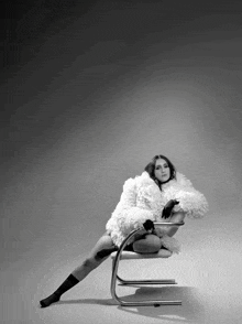 a woman is sitting on a chair with her legs crossed