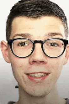 a young man wearing glasses is smiling in a close up of his face .