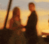 a blurry photo of a man and a woman holding hands