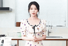 a woman in a floral dress is giving a peace sign