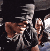 a man is blindfolded in a car with a woman