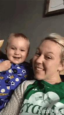 a woman is holding a little boy who is wearing a shirt that says ' soccer ' on it