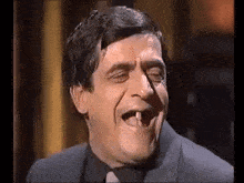 a man in a suit and tie has a tooth missing