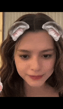 a close up of a woman wearing cat ears on her head .