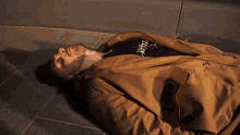 a man laying on the floor with a shirt that says hustle on it