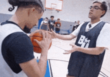 a man wearing a jersey with the letter b on it is holding a basketball