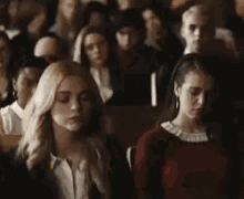 a group of young women are sitting in a classroom .