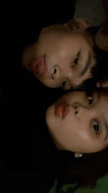 a boy and a girl are laying face to face
