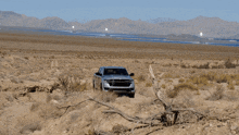 a silver ram truck is driving through a desert