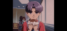 a boy in a red shirt is holding a hamburger in his hands