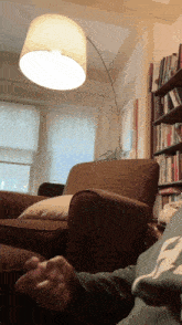 a person sits in a living room with a lamp on