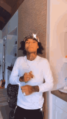 a man wearing a bandana and a white shirt is dancing in a room .